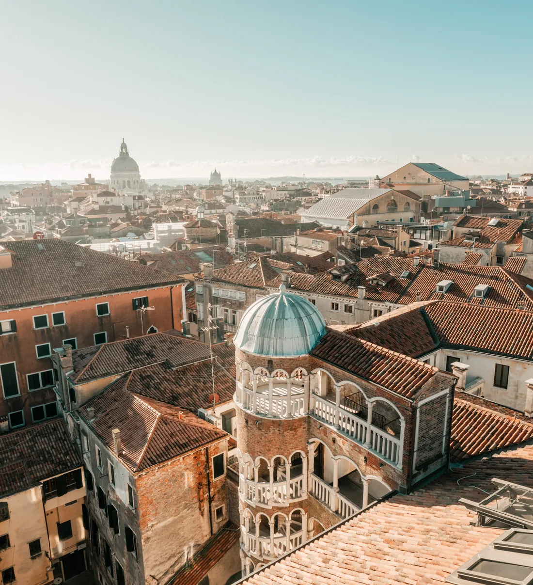 The spiral tower with its small dome seen from above, among the tiled rooftops of Venice