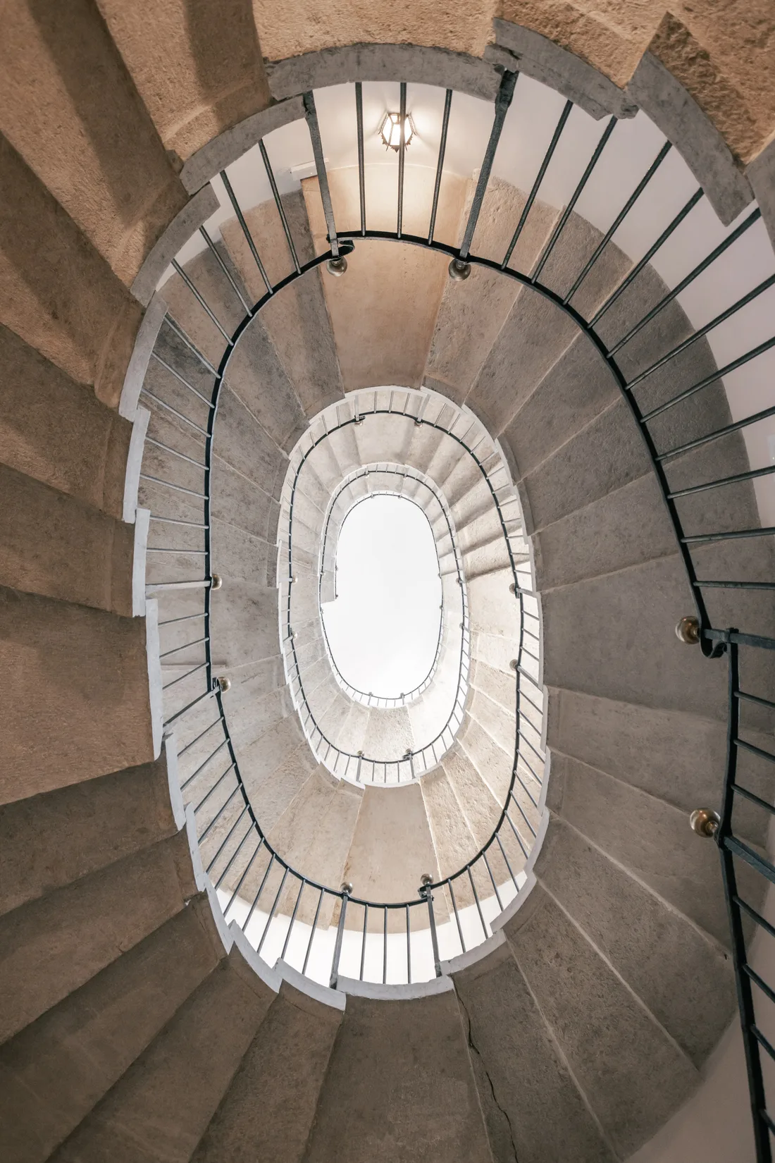 The spiral staircase seen from below, winding up towards the light