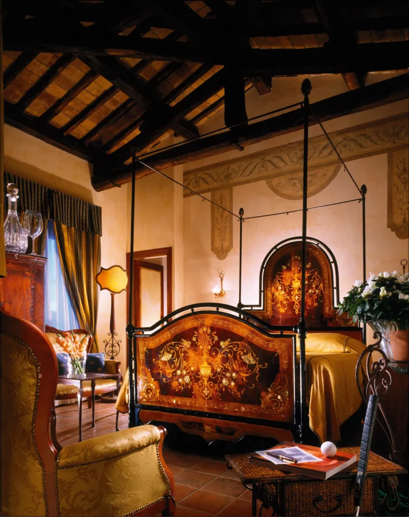 A castle suite with an antique four-poster bed, carved furniture and warm lights