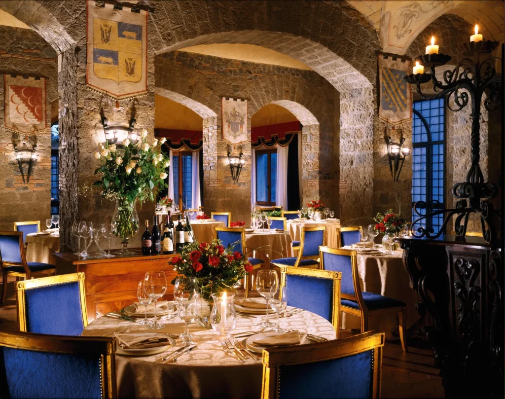 The castle restaurant with stone arches, candlelight and tables set for dinner