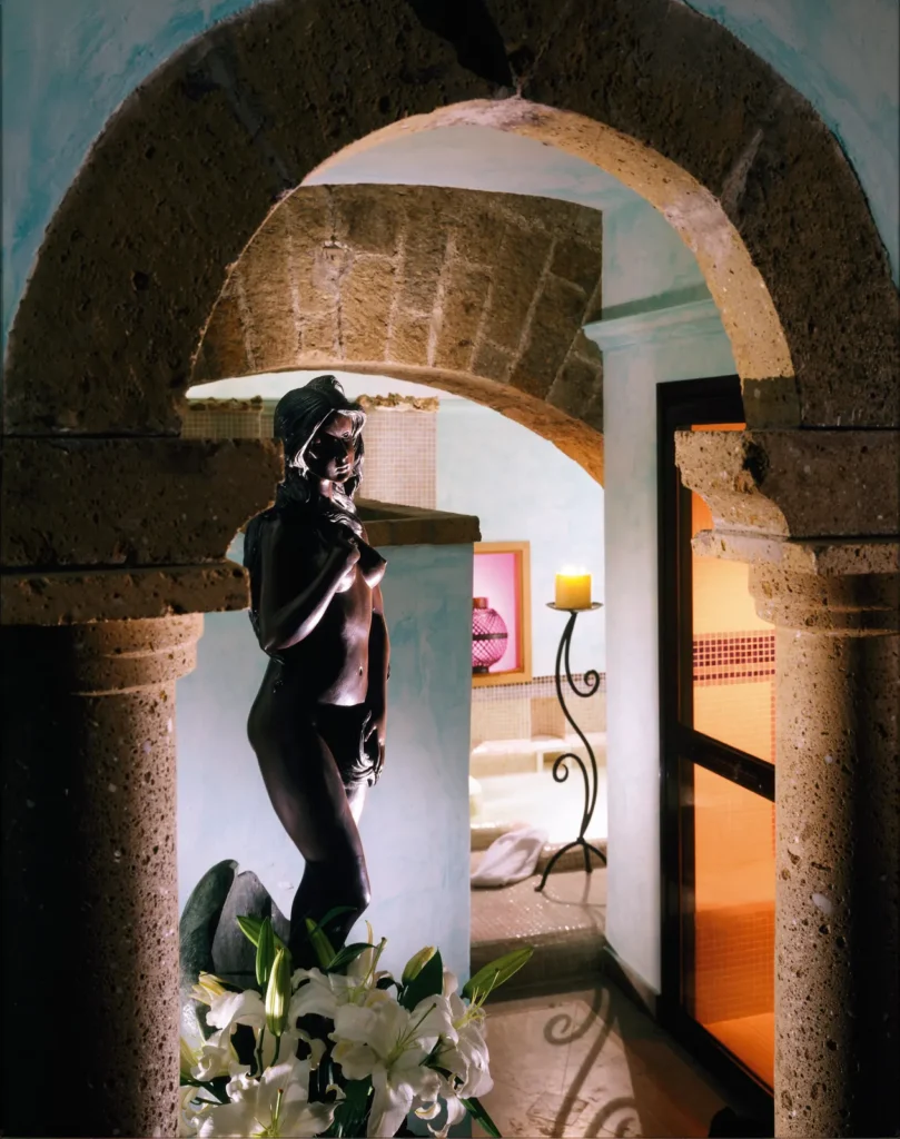 A stone arch with a classical statue in the castle spa