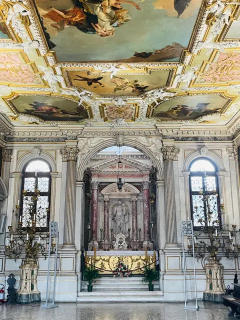 The marble altar of the Chapter Hall with candelabra, between two tall windows