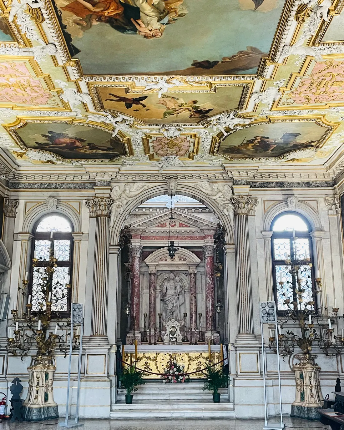 The marble altar of the Chapter Hall between two tall windows, under a gilded painted ceiling