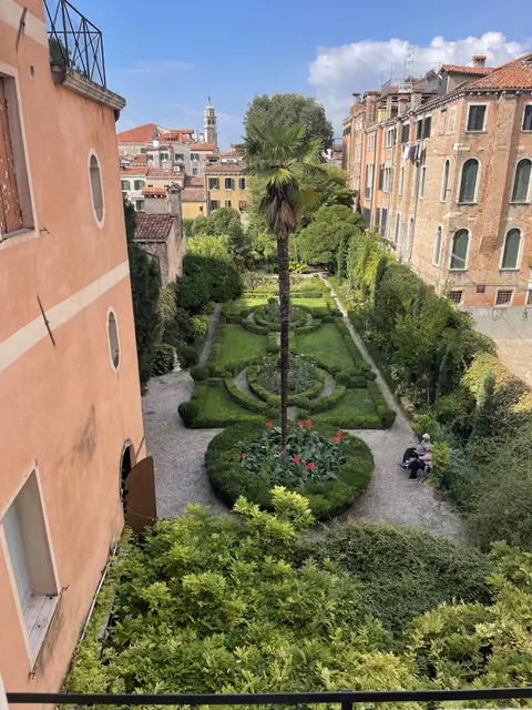 The Italian-style garden seen from above, with its palm tree, box hedges and gravel paths between Venetian houses
