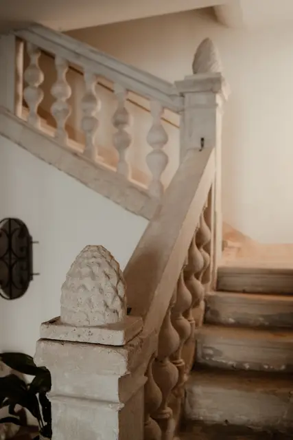 A carved stone staircase with balusters inside the palace